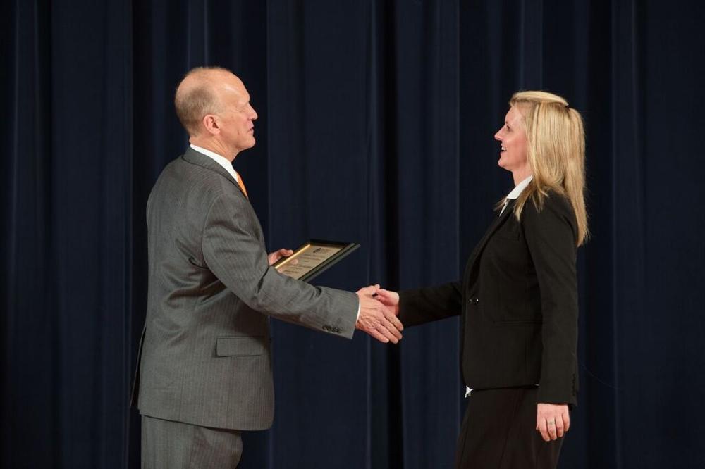 Doctor Potteiger shaking hands with an award recipeint in a black blazer